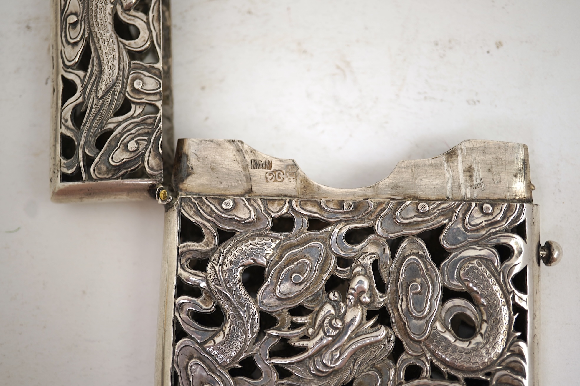 A late 19th century Chinese Export pierced silver card case, maker KMS(Kwong Man Shing), decorated with dragons amid clouds, 10.4cm, together with a Chinese Export pierced silver octagonal box and cover, by Luen Wo?, cir